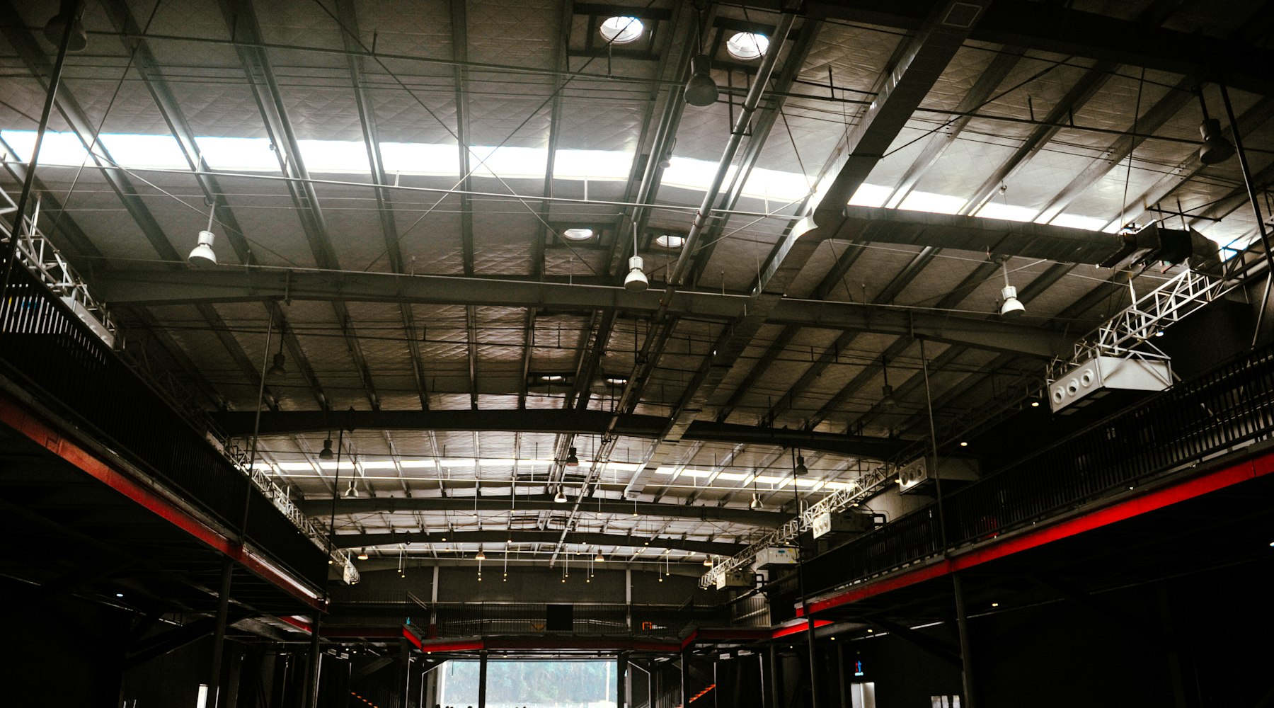 A large industrial interior with an overhead lighting grid.